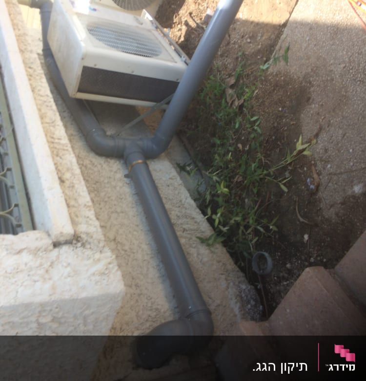 צינור אפור מחובר למזגן על גג